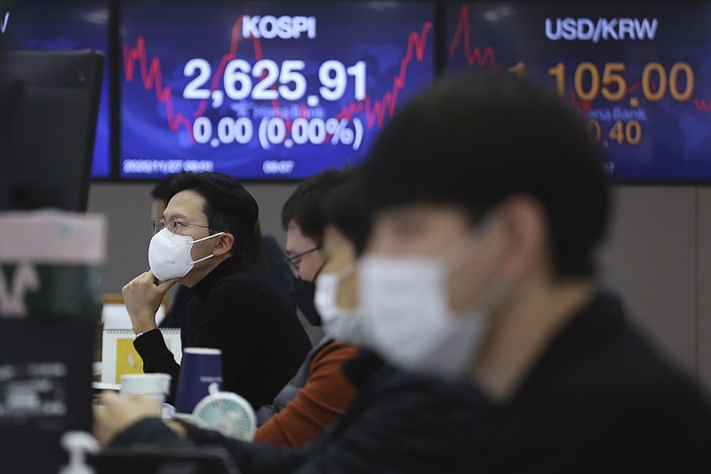 A currency trader watches monitors at the foreign exchange dealing room of the KEB Hana Bank headquarters in Seoul, South Korea, Friday, Nov. 27, 2020. Asian stock markets declined Friday as questions about the effectiveness of one possible coronavirus vaccine weighed on investor optimism. (AP Photo/Ahn Young-joon)