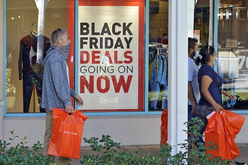 Shoppers wear protective face masks as they look for Black Friday deals at the Ellenton Premium Outlet stores Friday, Nov. 27, 2020, in Ellenton, Fla. Attendance at the mall was down in an attempt to avoid spreading the corona virus. (AP Photo/Chris O'Meara)


