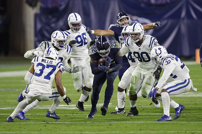 AP photo by Ben Margot / Tennessee Titans running back Derrick Henry is swarmed by a group of Indianapolis Colts defenders on Nov. 12 in Nashville. Henry rushed for 103 yards as the Titans lost to their AFC South rivals.