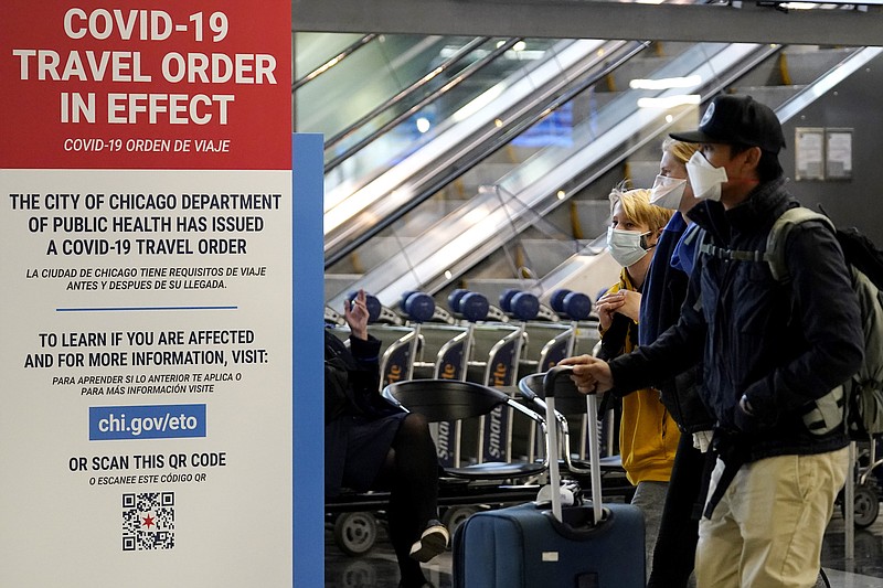 Photo by Nam Y. Huh of The Associated Press / Travelers walk through Terminal 3 as a COVID-19 travel order sign is displayed at O'Hare International Airport in Chicago on Sunday, Nov. 29, 2020.