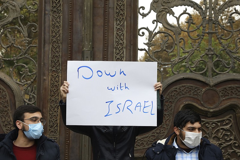 Photo by Vahid Salemi of The Associated Press / A protester holds an anti-Israeli placard during a gathering in front of Iranian Foreign Ministry on Saturday, Nov. 28, 2020, a day after the killing of Mohsen Fakhrizadeh, an Iranian scientist linked to the country's nuclear program.