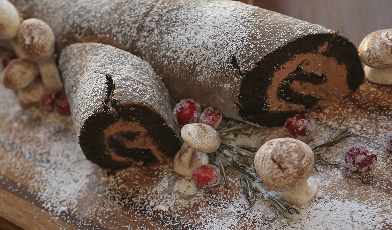 File Photo by John Sykes Jr. / Arkansas Democrat-Gazette / A traditional Buche de Noel (Yule Log) cake gets a dusting of snow from powdered sugar and mushrooms fashioned from meringue.