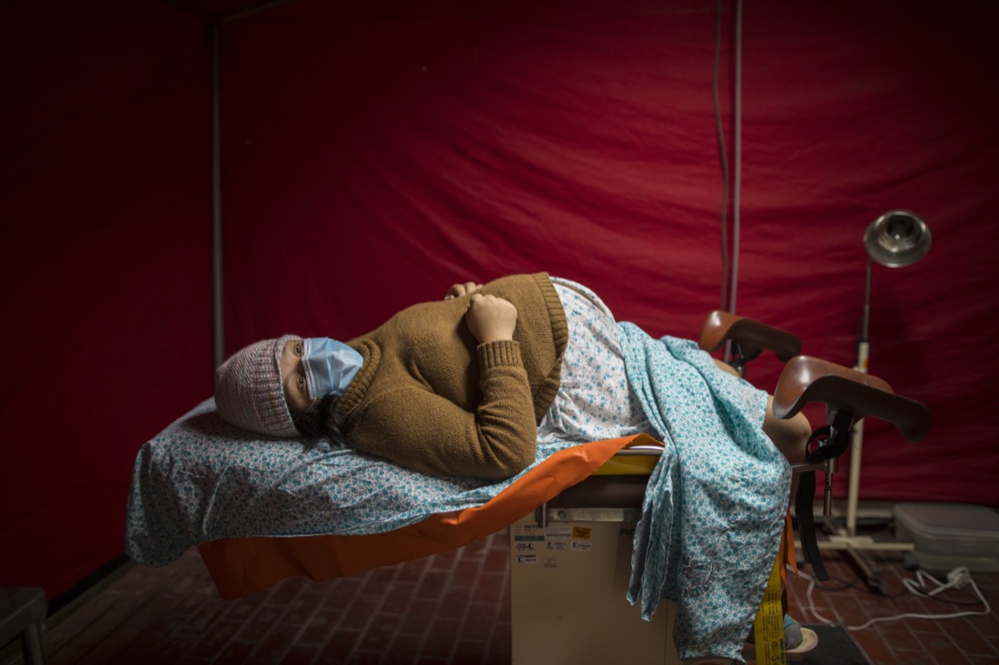 Olinda Tafur, 20, lies on an examination table as she waits to be seen by an obstetrician inside a tent set up in the emergency area of the National Perinatal and Maternal Institute to receive women in labor who are infected with COVID-19, in Lima, Peru, on July 29, 2020. Just before giving birth to her first child, Tafur learned that she had tested positive for the new coronavirus upon arriving with labor pains to the emergency area of the Institute. (AP Photo/Rodrigo Abd)
