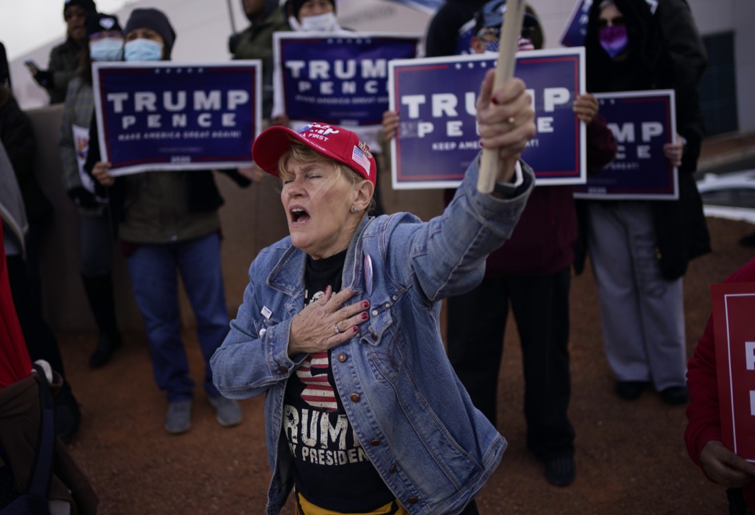 A supporter of President Donald Trump holds her hand over her heart during a protest of the election outside of the Clark County Election Department in North Las Vegas on Nov. 8, 2020. (AP Photo/John Locher)