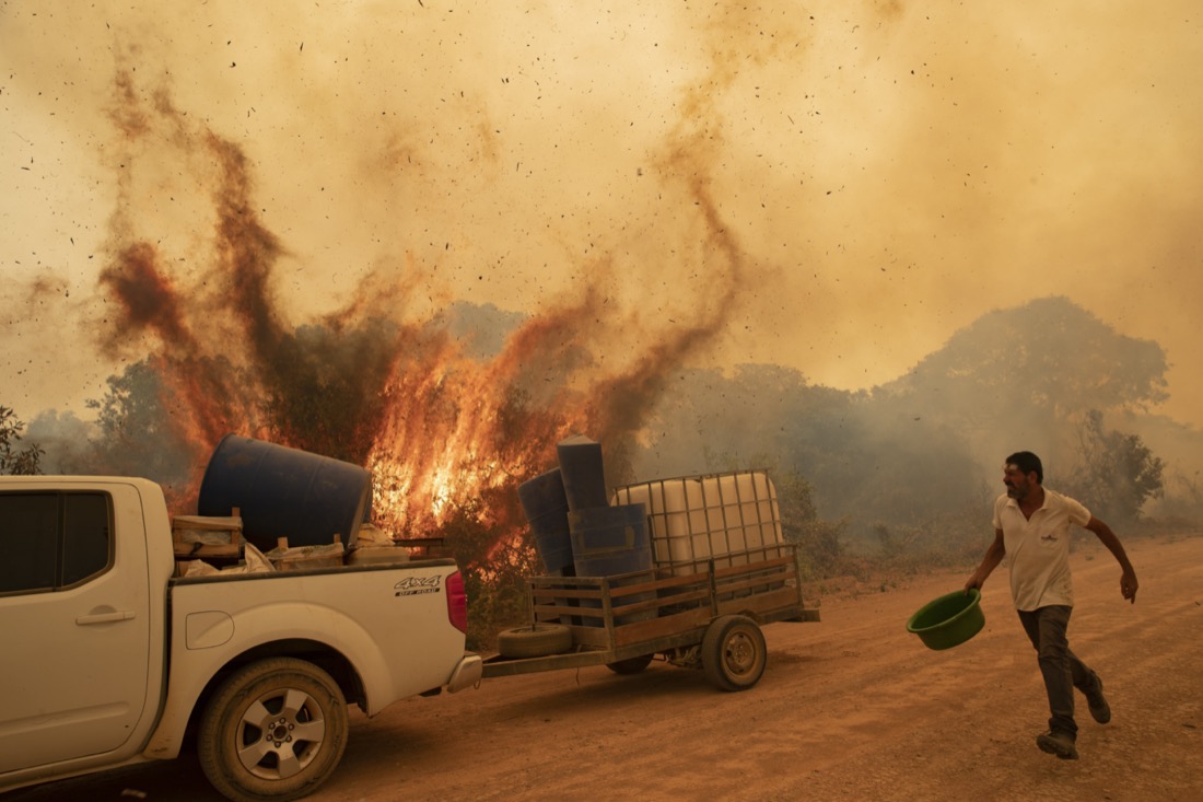 A volunteer tries to douse a fire on Transpantaneira road in the Pantanal wetlands near Pocone, Mato Grosso state, Brazil, on Sept. 11, 2020. The number of fires in Brazil's Pantanal, the world's biggest tropical wetlands, more than doubled in the first half of 2020 compared to the same period last year, according to data released by a state institute. (AP Photo/Andre Penner)