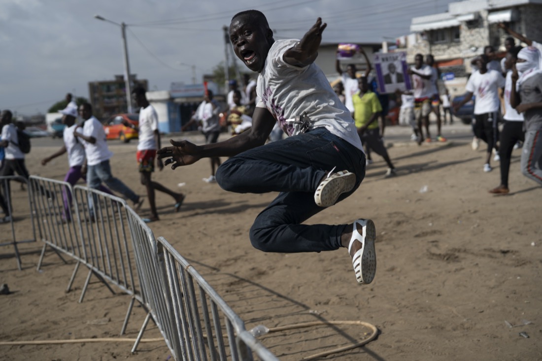 A supporter of presidential candidate Kouadio Konan Bertin jumps a fence as he arrives at Bertin's final campaign rally in Abidjan, Ivory Coast, on Oct. 29, 2020, ahead of the Oct. 31 election. (AP Photo/Leo Correa)