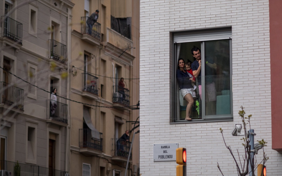 People stand in their balconies during a nationwide confinement to counter the coronavirus in Barcelona, Spain on March 29, 2020. (AP Photo/Emilio Morenatti)