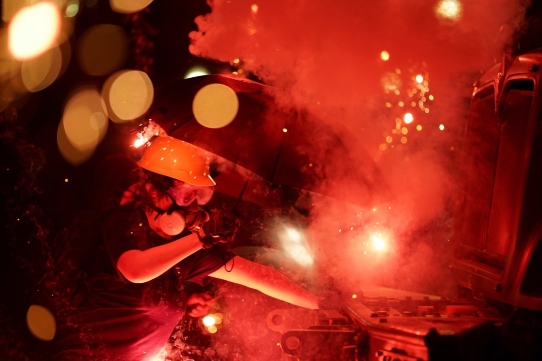 An explosive device detonates as a protester pushes back on an armored vehicle clearing the park of demonstrators during clashes outside the Kenosha County Courthouse late Tuesday, Aug. 25, 2020, in Kenosha, Wis. Protests have erupted following the police shooting of Jacob Blake two days earlier. (AP Photo/David Goldman)