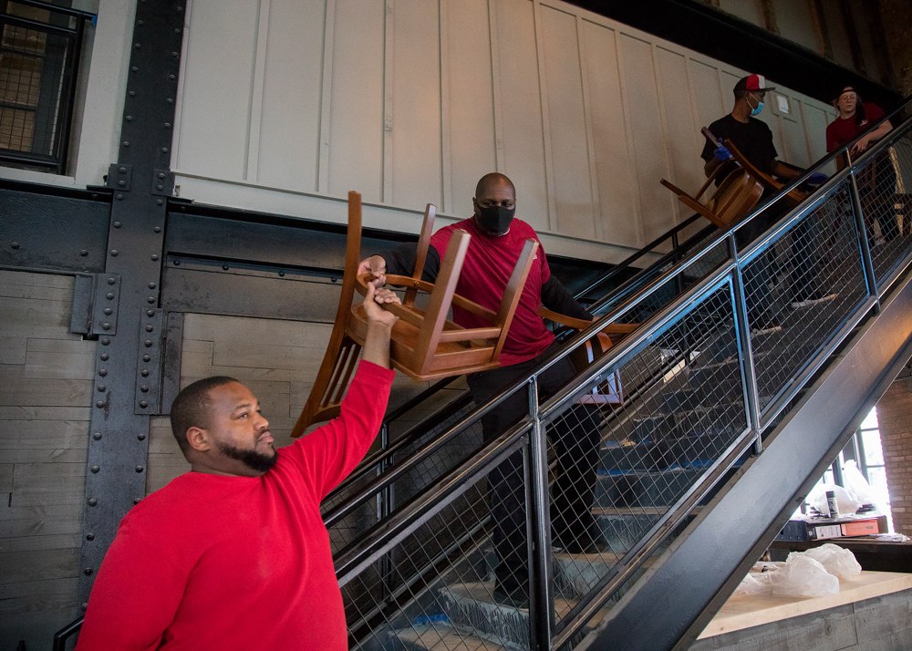 Staff photo by Troy Stolt / Nic & Norman's staff carry chairs into the main dining area on Tuesday, Dec. 1, 2020 in Chattanooga, Tenn. The restaurant, which planned to open in the spring of 2020 before the pandemic, now plans to open open its doors sometime next week.