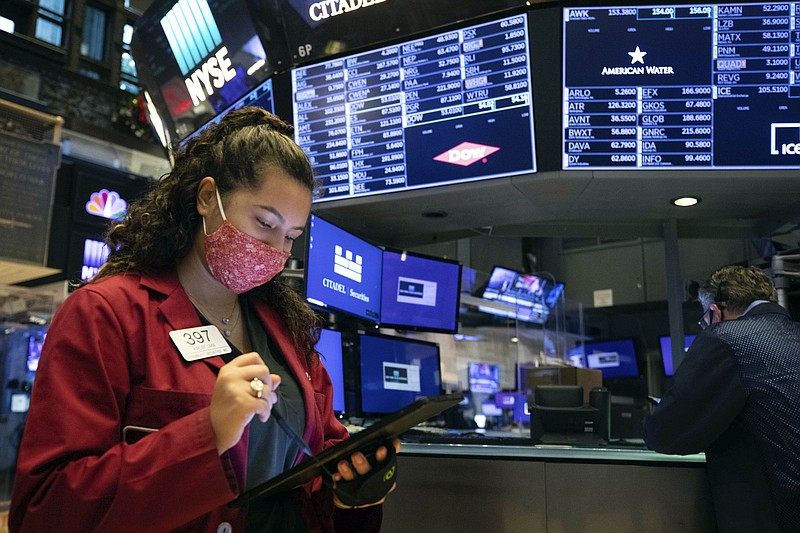 In this photo provided by the New York Stock Exchange, trader Ashley Lara uses her handheld device as she works on the trading floor, Tuesday, Dec. 1, 2020. U.S. stocks rose broadly in morning trading Tuesday, sending the S&P 500 toward another record high, as investors focus on the possibility that coronavirus vaccines could soon help usher in a fuller global economic recovery. (Colin Ziemer/New York Stock Exchange via AP)