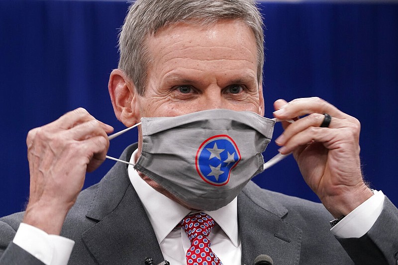 Tennessee Gov. Bill Lee puts on his mask during a break in the state budget hearings Tuesday, Nov. 10, 2020, in Nashville, Tenn. (AP Photo/Mark Humphrey)