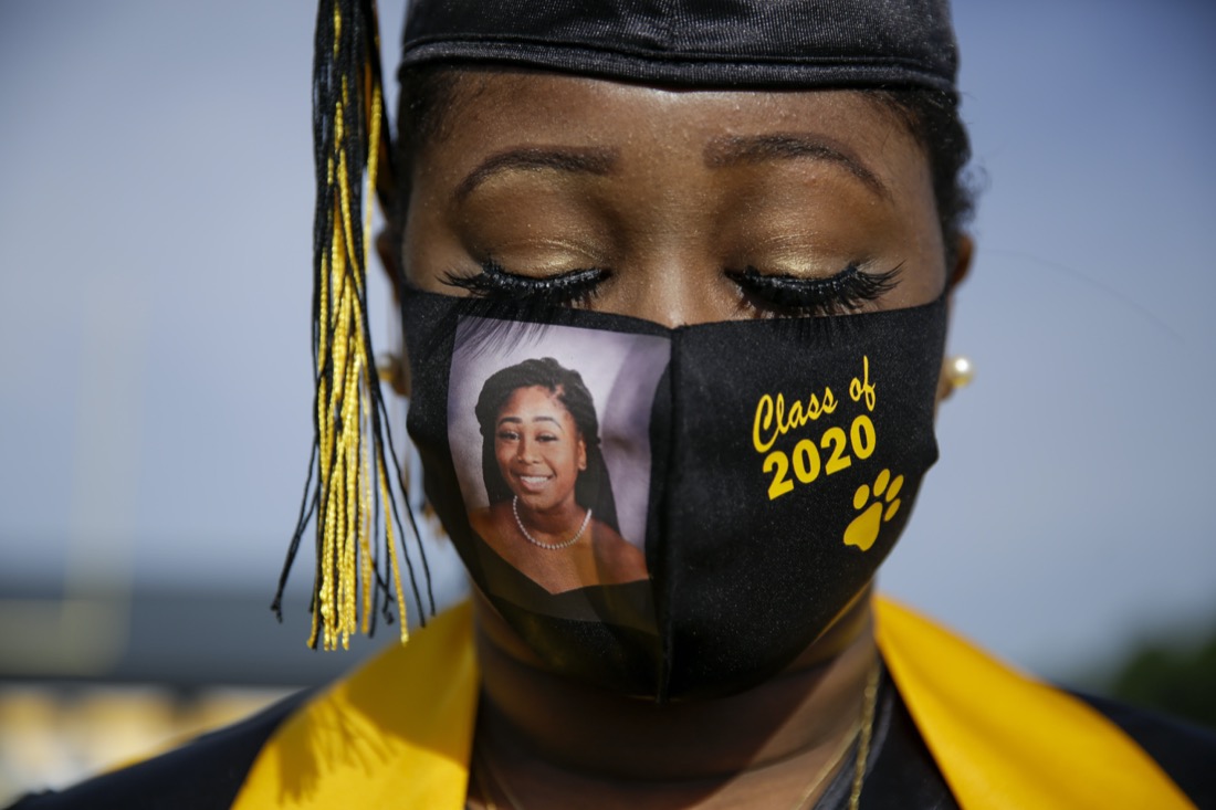 Yasmine Protho, 18, wears a photo of herself and "Class of 2020" on her protective mask amid the COVID-19 virus outbreak as she graduates with only nine other classmates and limited family attending at Chattahoochee County High School in Cusseta, Ga., on May 15, 2020. (AP Photo/Brynn Anderson)