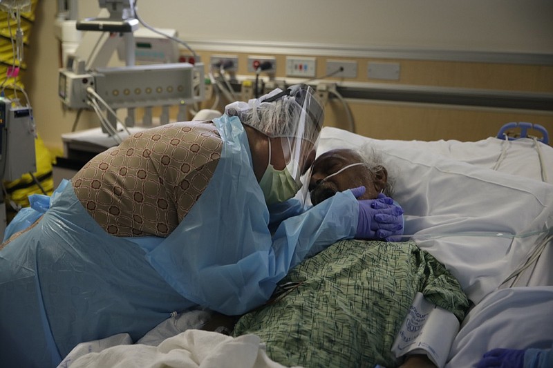 Romelia Navarro, 64, weeps while hugging her husband, Antonio, in his final moments in a COVID-19 unit at St. Jude Medical Center in Fullerton, Calif., on July 31, 2020. (AP Photo/Jae C. Hong)