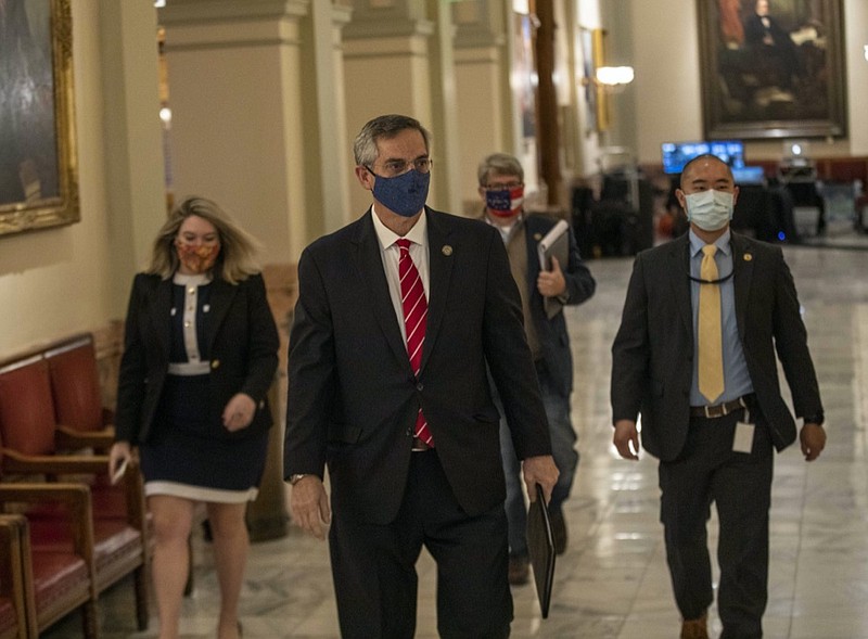 Georgia Secretary of State Brad Raffensperger, center, walks with members of his staff as they make their way to a press conference at the Georgia State Capitol building in Atlanta, Wednesday, Dec. 2, 2020. (Alyssa Pointer/Atlanta Journal-Constitution via AP)