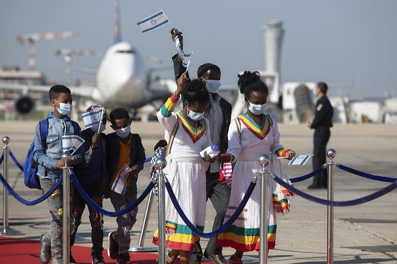 Ethiopian immigrants arrive at the Ben Gurion airport near Tel Aviv, Israel, Thursday, Dec. 3, 2020. Hundreds of Ethiopian immigrants on Thursday arrived to a festive ceremony at Israel's international airport, as the government took a step toward carrying out its pledge to reunite hundreds of families split between the two countries. (AP Photo/Sebastian Scheiner)