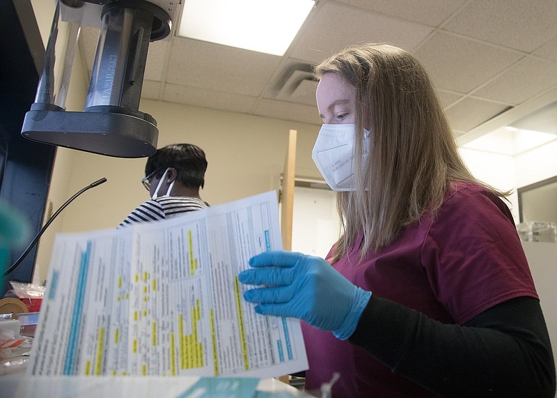 Staff photo by Troy Stolt / Health care worker Kristen Pennington looks through a Hamilton County resident's paperwork before bagging up their COVID-19 test provided by the non-profit organizations Alleo and CEMPA at Hospice of Chattanooga on Monday, Nov. 30, 2020 in Chattanooga, Tenn.