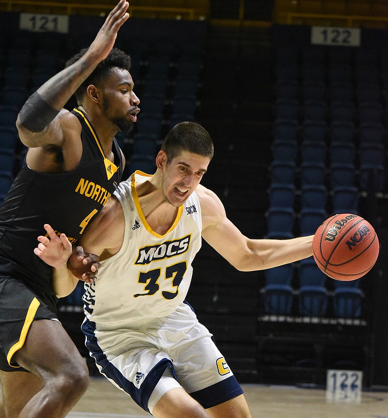 Staff photo by Matt Hamilton / UTC's Stefan Kenic drives toward the hoop as Northern Kentucky's Adrian Nelson defends during Saturday's game at McKenzie Arena. Kenic scored 17 points and had a team-high seven assists as the Mocs won 79-72.