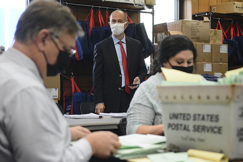 FILE - In this Nov. 10, 2020, file photo, Republican poll watcher Douglas Bucklin, center, observes as Schuylkill County Election Bureau Director Albert L. Gricoski, left, and staffer Christine Marmas, right, open provisional ballots in Pottsville, Pa. Even after he exits the White House, President Donald Trump's scorched-earth strategy of challenging the legitimacy of elections and seeking to overturn the will of the voters by any means necessary could have staying power. (Lindsey Shuey/Republican-Herald via AP, File)