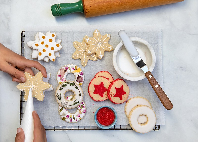 From a basic sugar cookie dough, you can create three kinds of cookies, from left, Glittering Snowflakes, Floral Wreaths and Slice-and-Bake Stars. / Christine Chitnis/The New York Times