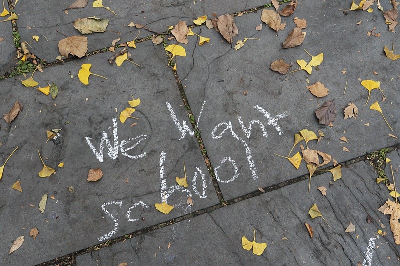 A student's graffiti is written on a sidewalk in front of New York's City Hall during a protest by parents and students opposing the closing of schools, Thursday, Nov. 19, 2020. Mayor Bill de Blasio announced Wednesday that the nation's largest school system will move to remote learning only as the city tries to tamp down a growing number of coronavirus cases. (AP Photo/Mark Lennihan)