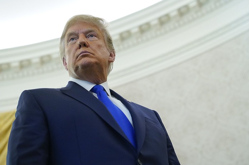 President Donald Trump listens to a reporter's question after awarding the Presidential Medal of Freedom, the highest civilian honor, to Olympic gold medalist and former University of Iowa wrestling coach Dan Gable in the Oval Office of the White House, Monday, Dec. 7, 2020, in Washington. (AP Photo/Patrick Semansky)

