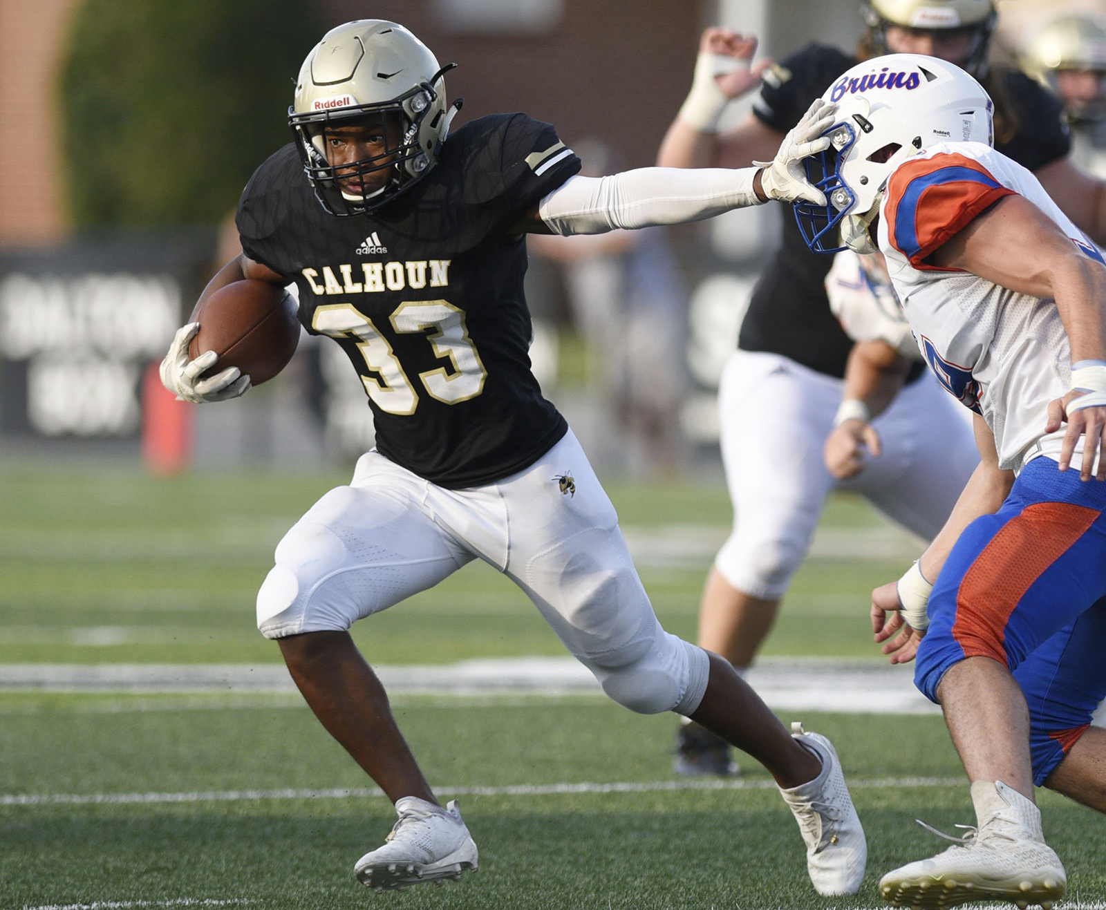 Staff photo by Robin Rudd / Calhoun running back Jerrian Hames (33) stiff-arms a Northwest Whitfield defender during a scrimmage on Aug. 9, 2019, at Phil Reeve Stadium in Calhoun, Ga.
