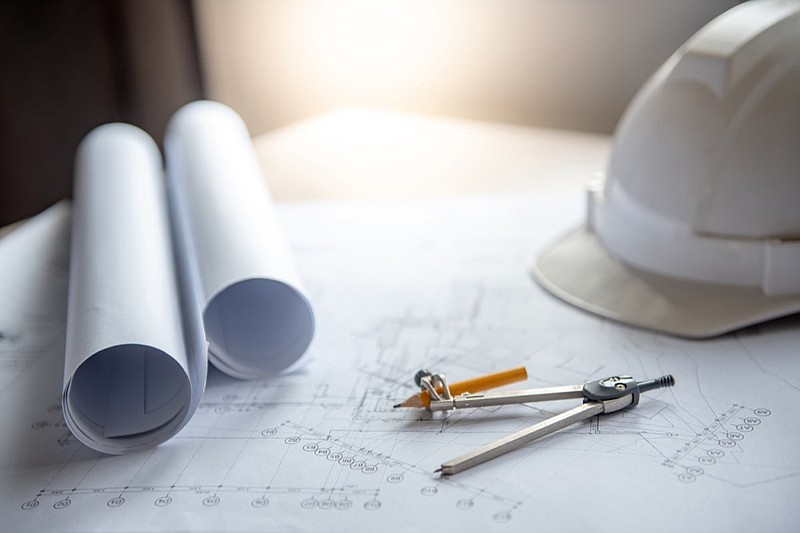 Compass tool and safety helmet on architectural drawing plan of house project, blueprint rolls on working table, Architecture and building construction industry concepts housing tile - stock photo