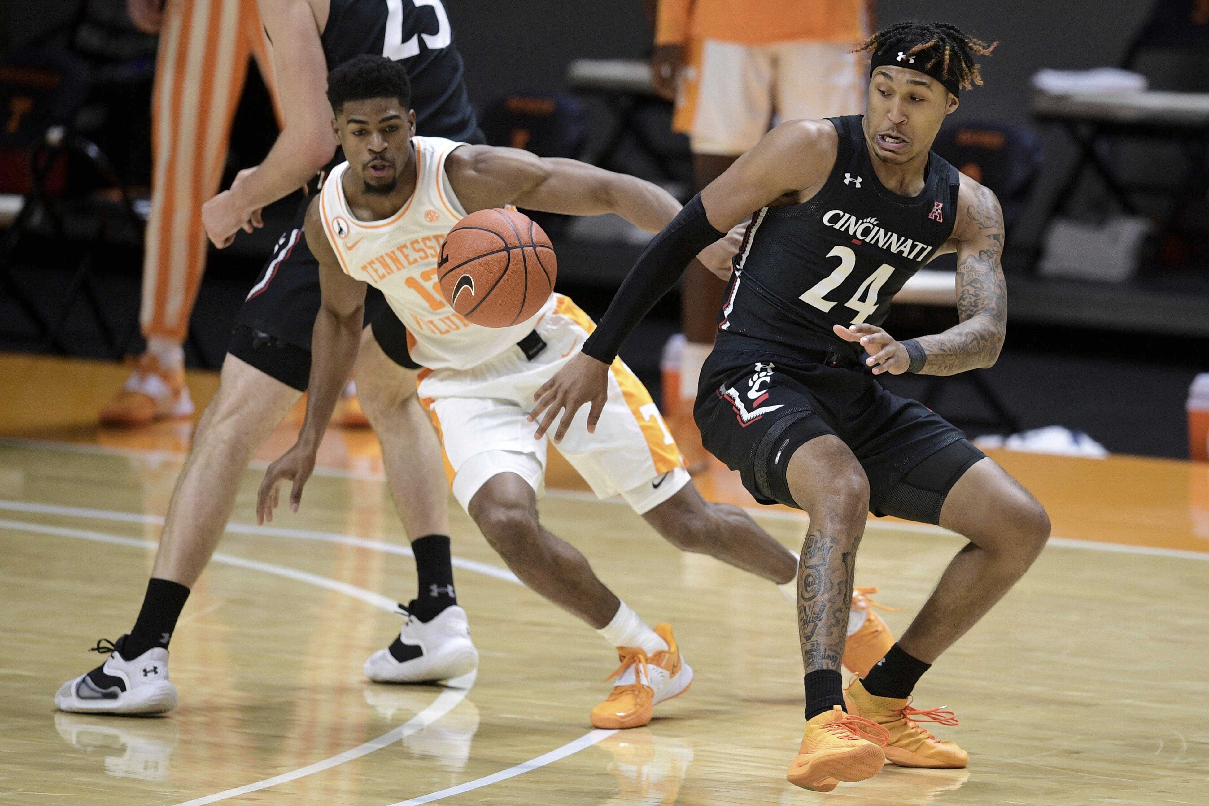 AP photo by Calvin Mattheis / Cincinnati guard Jeremiah Davenport (24) loses control of the ball as Tennessee's Victor Bailey Jr. goes after it during the first half of Saturday's game in Knoxville. Tennessee won 65-56 to improve to 2-0.