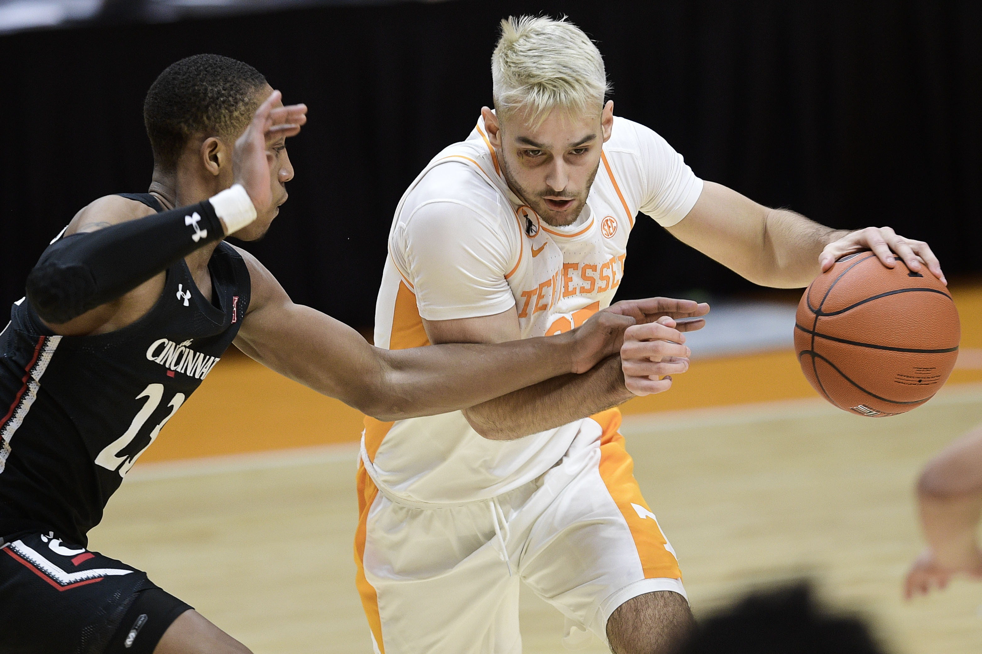 AP photo by Calvin Mattheis / Tennessee guard Santiago Vescovi dribbles as Cincinnati's Mika Adams-Woods defends Saturday in Knoxville.