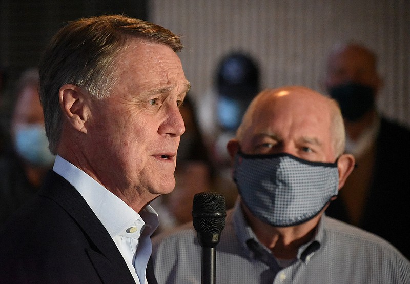 Staff Photo by Matt Hamilton / Sen. David Perdue speaks to a crowd of supporters as former Governor Sonny Perdue looks on at the Dalton Municipal Airport on Monday, Dec. 14, 2020.