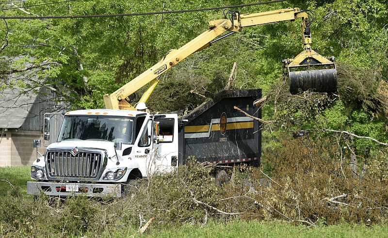 Staff Photo by Robin Rudd / A City of Chattanooga Department of Public Works employee fills a brush truck as storm debris from the April 12th EF3 tornado is removed from along Davidson Road in East Brainerd on April 22, 2020. City employees who weathered a pandemic and tornado are due for a holiday bonus.