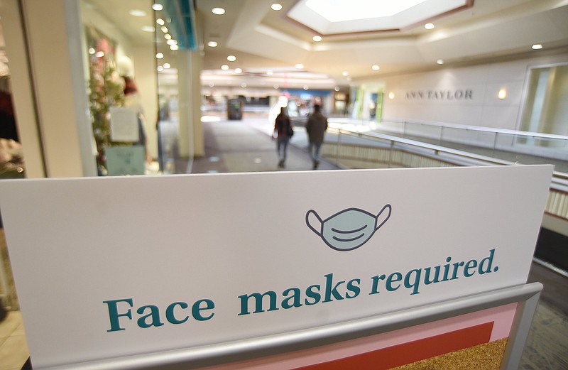 Staff Photo by Matt Hamilton / A sign in front of Maurice's at Hamilton Place Mall reminds shoppers to wear face masks.