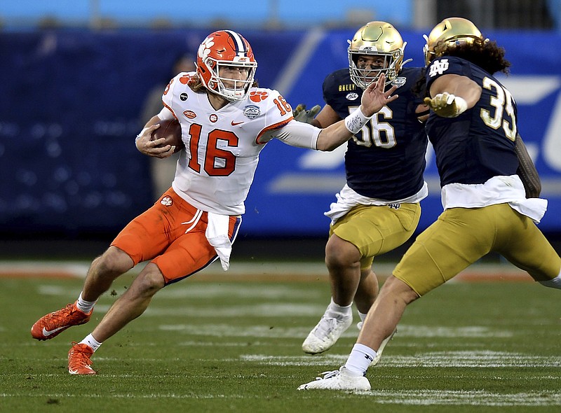 AP photo by Jeff Siner / Clemson quarterback Trevor Lawrence, left, runs the ball during Saturday's ACC title game against Notre Dame in Charlotte, N.C.