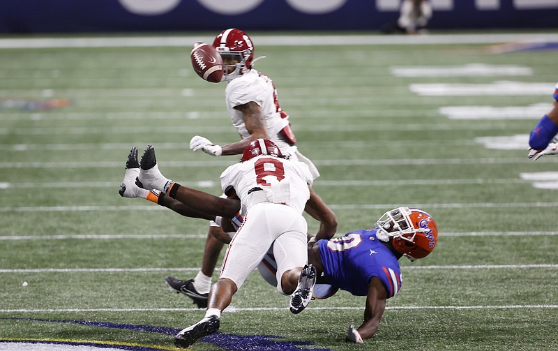 Crimson Tide photos / Alabama receiver John Metchie (8) levels Florida safety Trey Dean during Saturday night's SEC title game in Atlanta. Dean fumbled as a result of the hit after coming up with an interception, with Crimson Tide receiver DeVonta Smith, background, recovering the fumble.