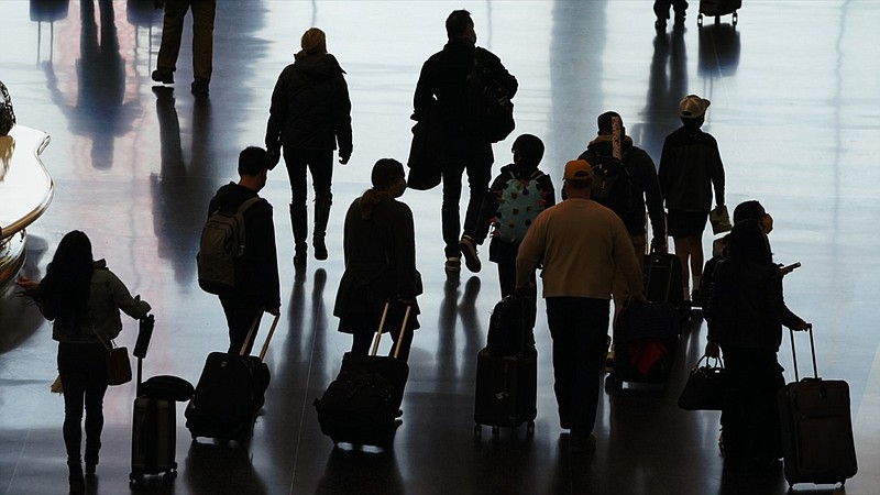 FILE - In this Nov. 25, 2020 file photo, travelers walk through the Salt Lake City International Airport in Salt Lake City, a day before Thanksgiving. More than 1 million people have passed through U.S. airport security checkpoints in each of the past two days in a sign that public health pleas to avoid holiday travel are being ignored, despite an alarming surge in COVID-19 cases. (AP Photo/Rick Bowmer, File)