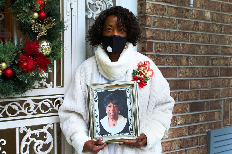 Staff photo by Wyatt Massey / Liz Cooper stands outside her Chattanooga home on Dec. 16, 2020, holding a picture of her mother, Mildred Jean Williams. Cooper's mother died from COVID-19 in November and Cooper still wonders whether the decision to place her in a care facility in March was a mistake.