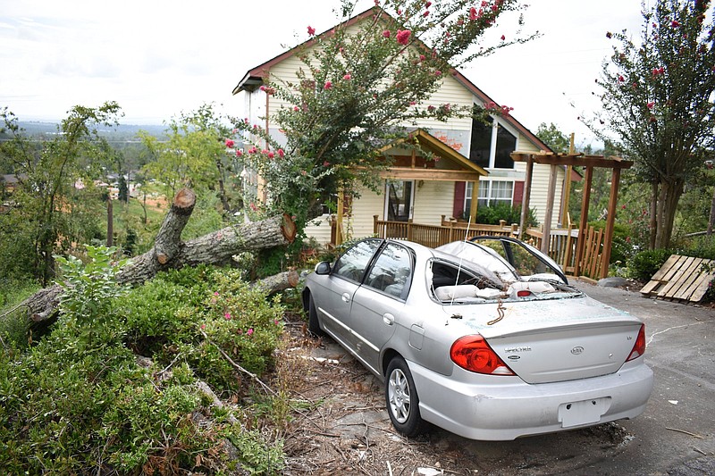 Staff File Photo By Matt Hamilton / A crushed car sits in a driveway in the Holly Hills subdivision after the Easter evening tornado in April.