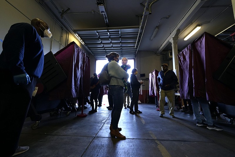 Amanda Bohren holds her one-year-old son, Luke Spencer Bohren, as she waits to vote on Election Day, in the Mid City section of New Orleans, Tuesday, Nov. 3, 2020. (AP Photo/Gerald Herbert)