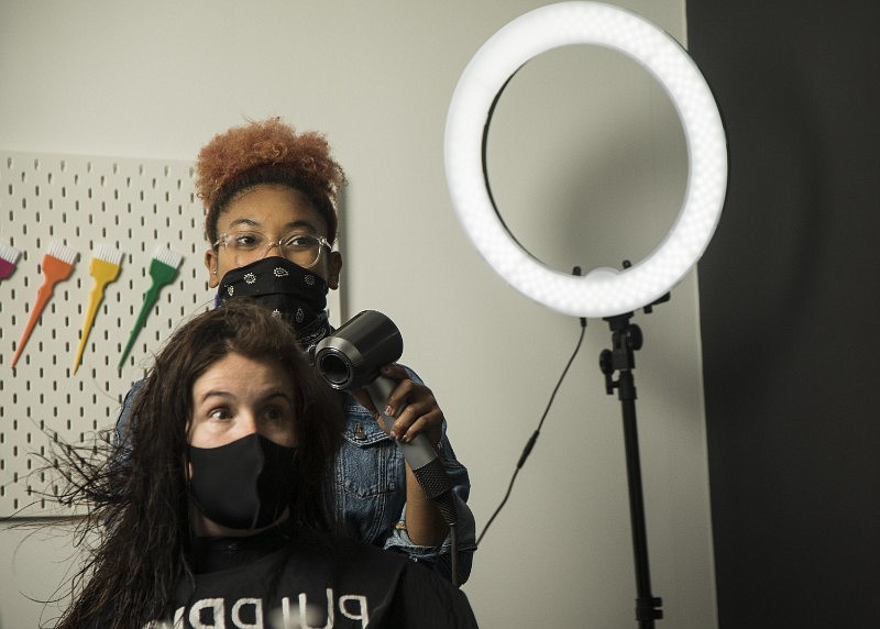 Shaina Ramsey styles a client's hair for a maternity photo shoot at Copycat Salon. / Staff Photo by Troy Stolt