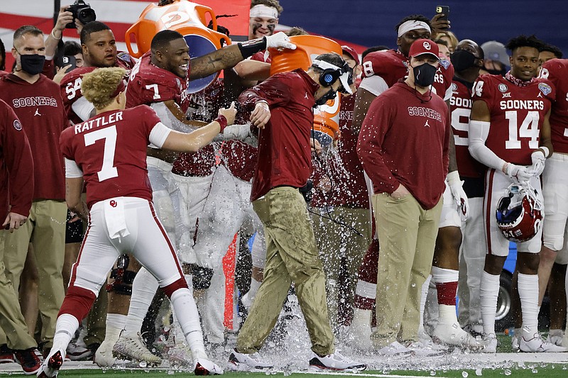 AP photo by Michael Ainsworth / Oklahoma quarterback Spencer Rattler watches as defensive end Ronnie Perkins douses coach Lincoln Riley in the closing seconds of the team's Cotton Bowl win against Florida on Wednesday night in Arlington, Texas.