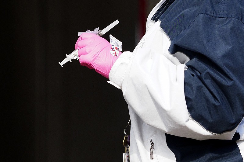 Staff photo by C.B. Schmelter / Hamilton County Health Department worker Shelly Donahue holds a dose of the COVID-19 vaccine near the Hubert Fry Center at the Tennessee Riverpark on Wednesday, Dec. 30, 2020 in Chattanooga, Tenn. The Hamilton County Health Department continued distributing vaccines following the State of Tennesseeճ response plan at their Vaccination Drive-Thru Point of Dispensing.