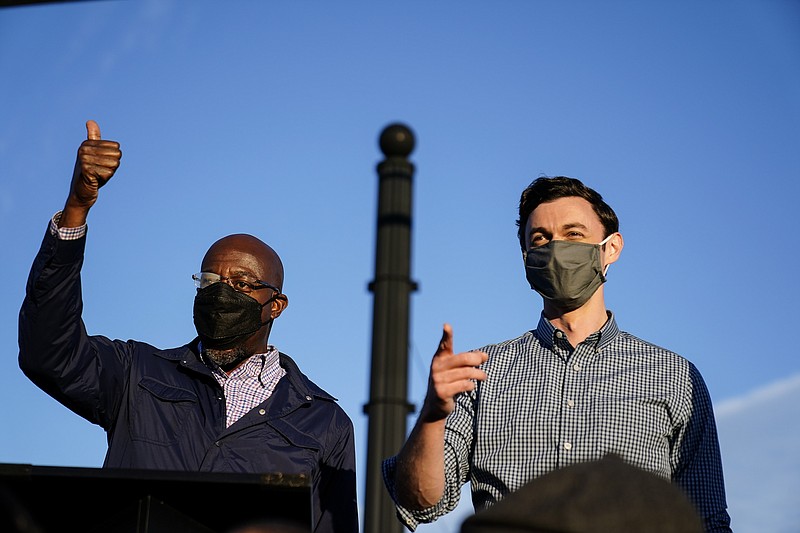 Associated Press File Photo / Georgia Democratic candidates for U.S. Senate Raphael Warnock, left, and Jon Ossoff, right, gesture toward a crowd during a campaign rally in November in Marietta.