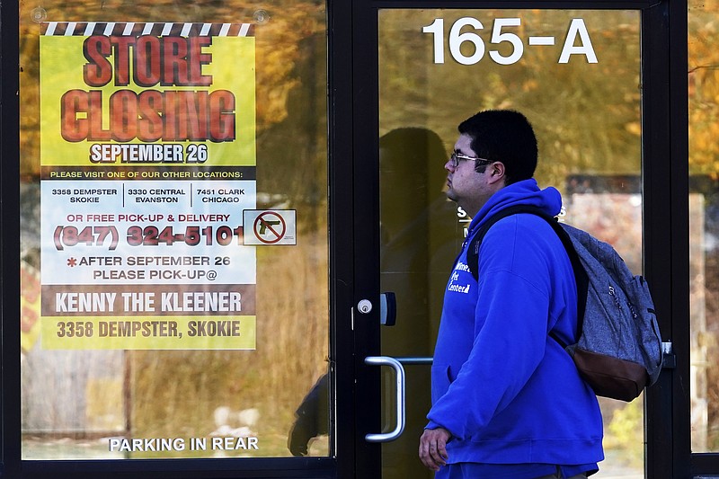 In this Friday, Nov. 6, 2020, file photo, a man walks past a closed store in Wilmette, Ill., amid the coronavirus pandemic. Responses to the coronavirus pandemic and police brutality dominated legislative sessions in 2020 and led to many new laws that will take effect in the new year. (AP Photo/Nam Y. Huh, File)