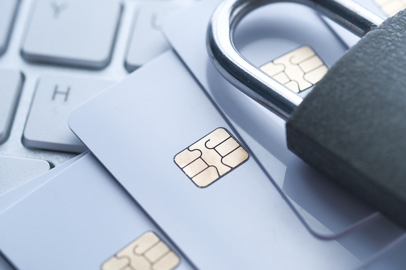 Close up of credit card and padlock scam theft prevention tile money lock / Getty Images
