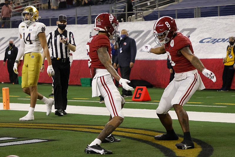 Alabama wide receiver DeVonta Smith (6) and wide receiver John Metchie III (8) celebrate Smith's touchdown catch as Notre Dame safety Kyle Hamilton (14) walks away in the first half of the Rose Bowl NCAA college football game in Arlington, Texas, Friday, Jan. 1, 2021. (AP Photo/Michael Ainsworth)