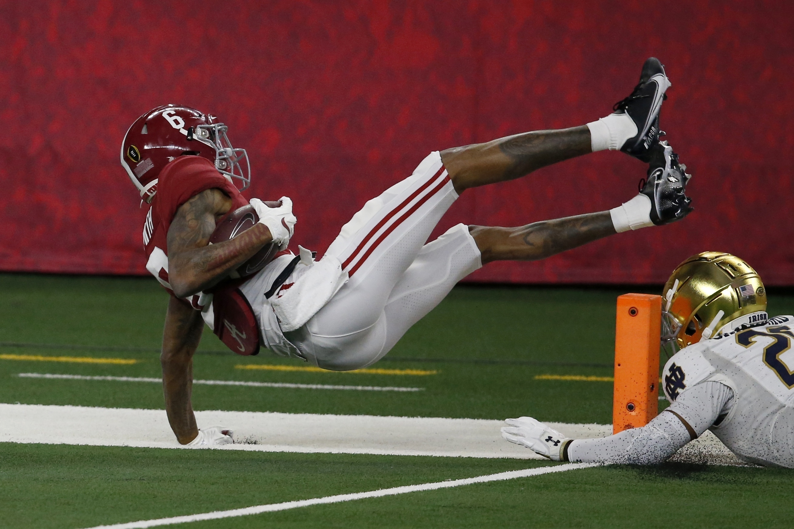 Alabama wide receiver DeVonta Smith (6) leaps into the end zone or a touchdown after getting past Notre Dame safety Shaun Crawford (20) in the first half of the Rose Bowl NCAA college football game in Arlington, Texas, Friday, Jan. 1, 2021. (AP Photo/Roger Steinman)
