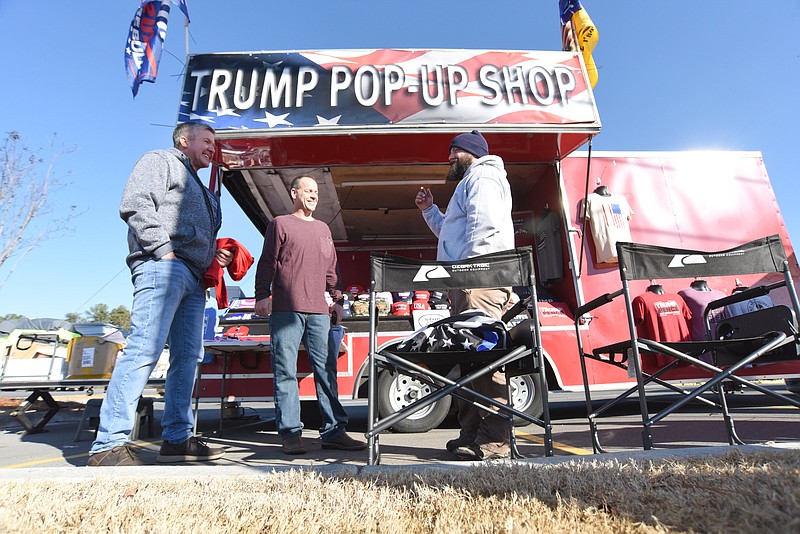 Staff Photo by Matt Hamilton / New York residents Tom Walsh, left, and Steve Isabell, middle, talk with Jeremy Boyts as he operates the "Trump Pop-Up Shop" which is based out of Springfield, Missouri, in front of the Food City along W. Walnut Ave. in Dalton, Ga. on Monday, Jan. 4, 2021.
