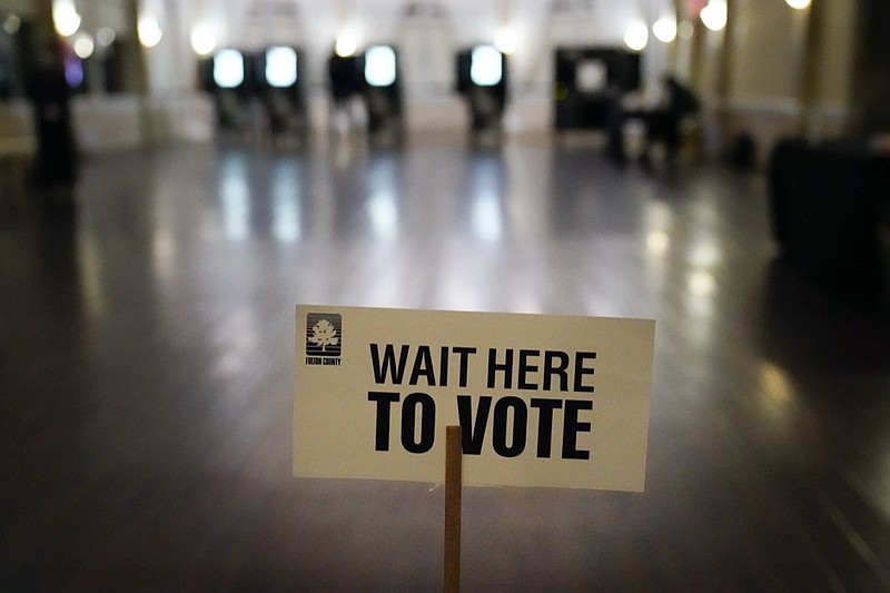 A sign is displayed for voters to guide the way at a precinct during Georgia's Senate runoff elections on Tuesday, Jan. 5, 2021, in Atlanta. (AP Photo/Brynn Anderson)