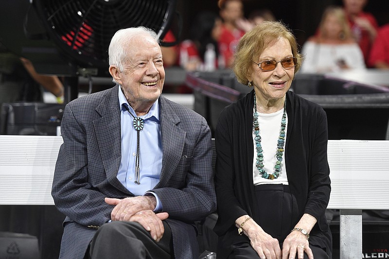 In this Sept. 30, 2018 file photo, former President Jimmy Carter and Rosalynn Carter are seen ahead of an NFL football game between the Atlanta Falcons and the Cincinnati Bengals, in Atlanta. Former President Jimmy Carter and former first lady Rosalynn Carter will not attend President-elect Joe Biden's inauguration. It marks the first time the couple, 96 and 93, will have missed the ceremonies since Carter was sworn-in as the 39th president in 1977.(AP Photo/John Amis, File)