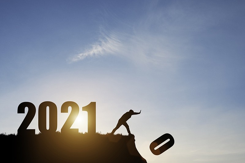 Man push number zero down the cliff where has the number 2021 with blue sky and sunrise. It is symbol of starting and welcome happy new year 2021. / Getty Images
